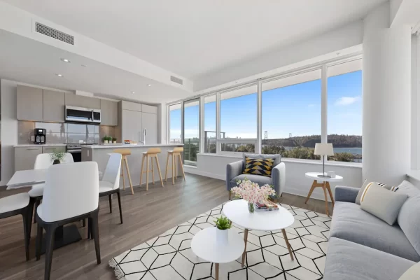 Spacious modern apartment layout at Gateway Residences featuring a sleek kitchen with an island breakfast bar, a dining area, and a bright living room overlooking the ocean.